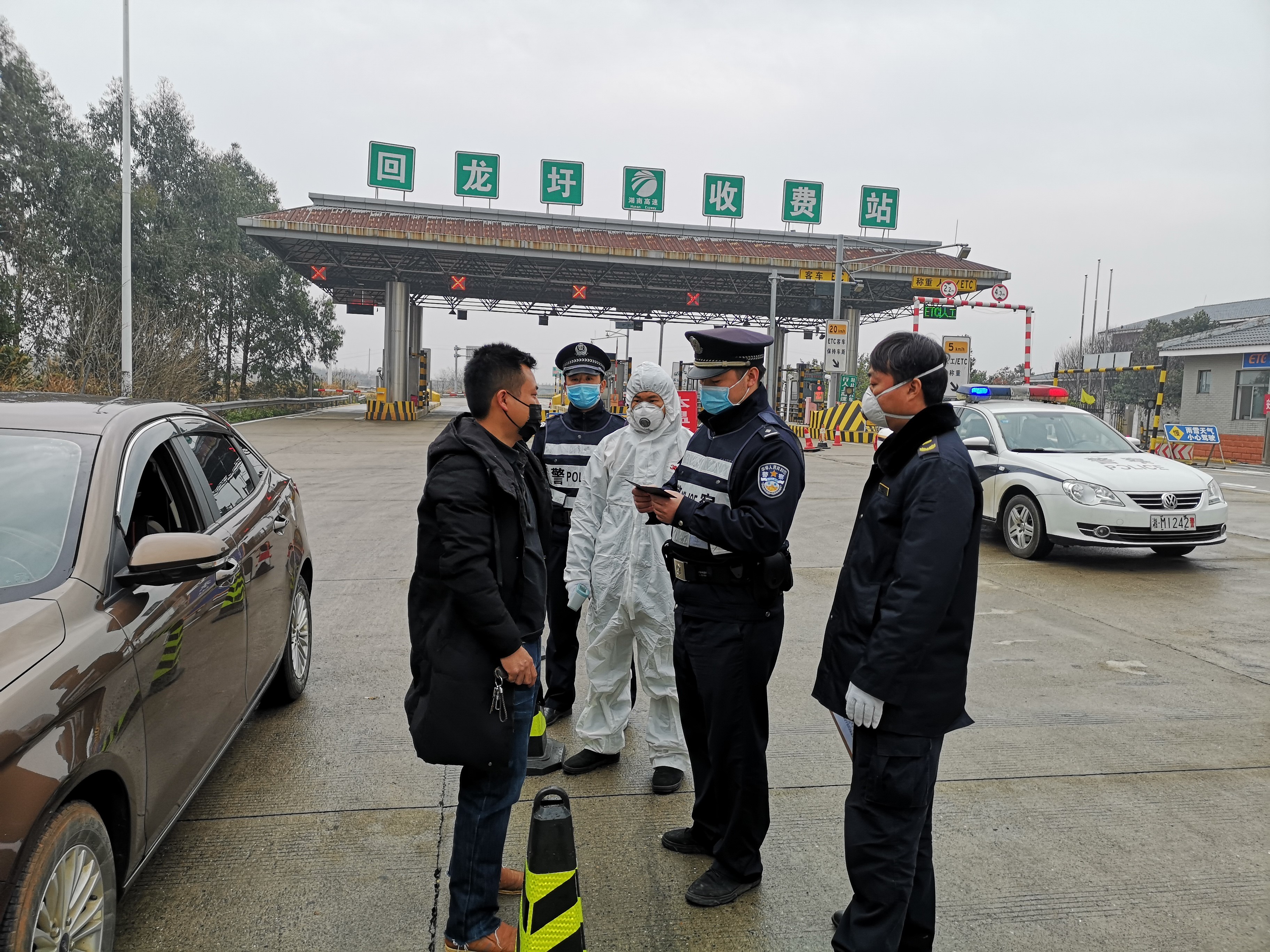 周永永(右二)带领辅警在道贺高速回龙圩出口协助卫生健康部门对过往